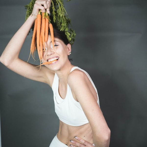 Smiling woman stretching gently outdoors, feeling energetic and full of life.